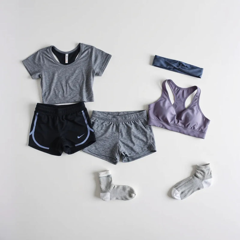 Assorted breathable athletic clothing and accessories neatly arranged on a neutral background